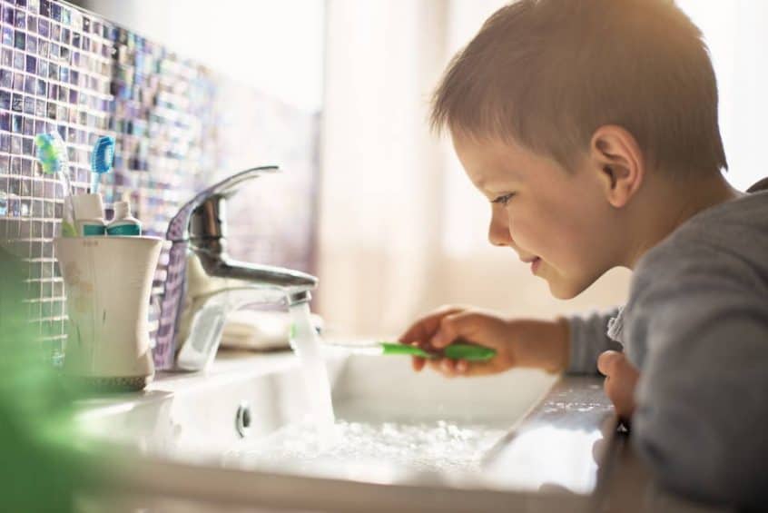 Child Brushing Teeth Which Running Faucet